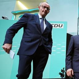 Friedrich Merz (l) und Carsten Linnemann verlassen nach einer Pressekonferenz ein Podium.