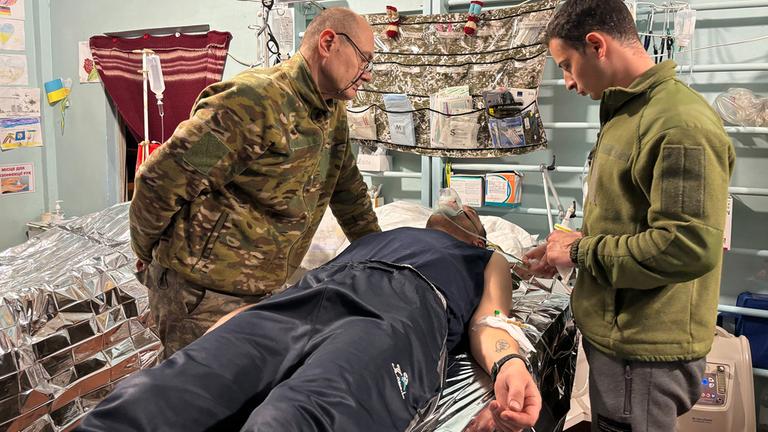 Chefchirurg Viktor Rodin (links) und Chirurg Olexandr Kosse untersuchen einen verletzten Soldaten