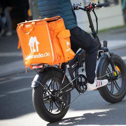 Ein Fahrer für den Essenslieferdienst Lieferando fährt über eine Straße