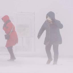 Zwei Frauen kämpfen sich durch einen Schneesturm
