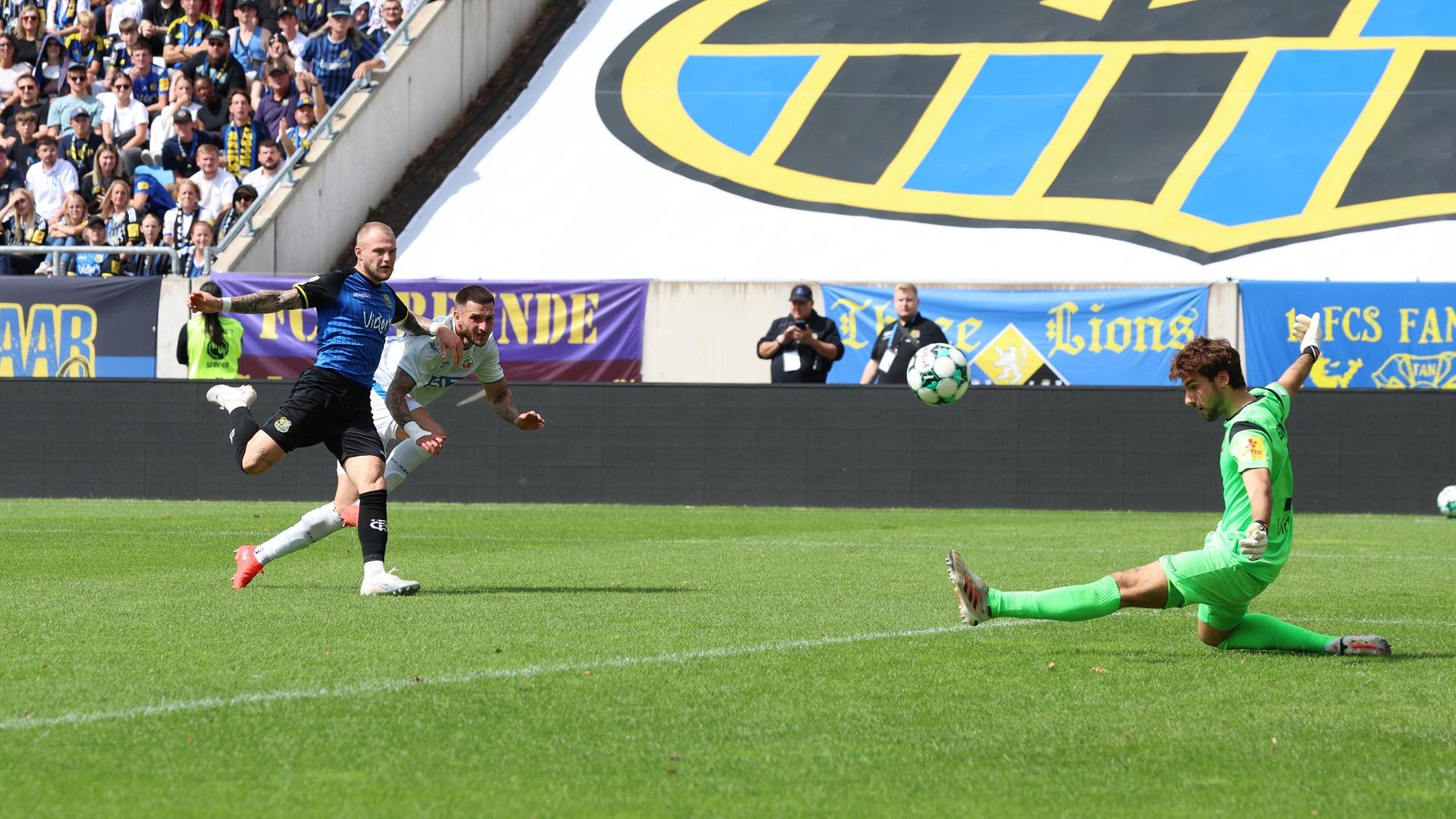 Philip Fahrner (1. FC Saarbruecken) Leon Dajaku (FC Hansa Rostock) und der Saarbrücker Keeper Matteo Bignetti | IMAGO / Jan Huebner