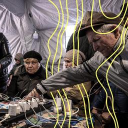 Während eines totalen Stromausfalls nach russischen Luftangriffen auf die Energieversorgung in Tschernihiw, Ukraine, am Dienstag laden Menschen ihre Telefone in einem Zelt auf.