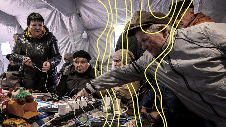 Während eines totalen Stromausfalls nach russischen Luftangriffen auf die Energieversorgung in Tschernihiw, Ukraine, am Dienstag laden Menschen ihre Telefone in einem Zelt auf.