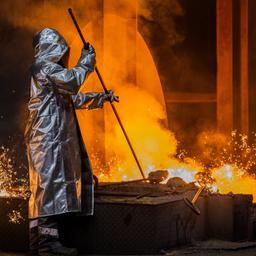 Ein Stahlarbeiter von Thyssenkrupp prüft den Roheisen am Hochofen 8 auf dem Werksgelände in Duisburg (Archivbild). 