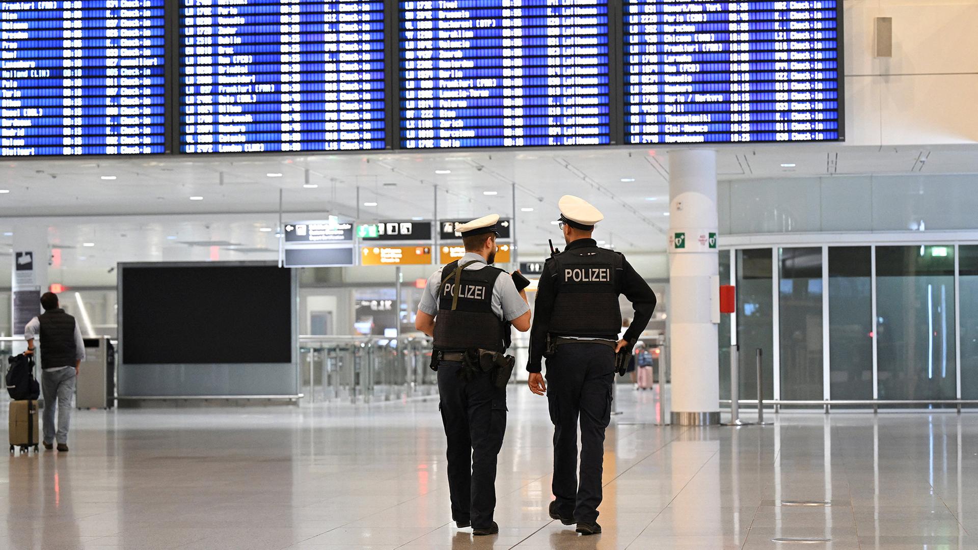 Polizeibeamte gehen durch einen Terminal am Flughafen München. | REUTERS