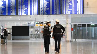 Polizeibeamte gehen durch einen Terminal am Flughafen München.