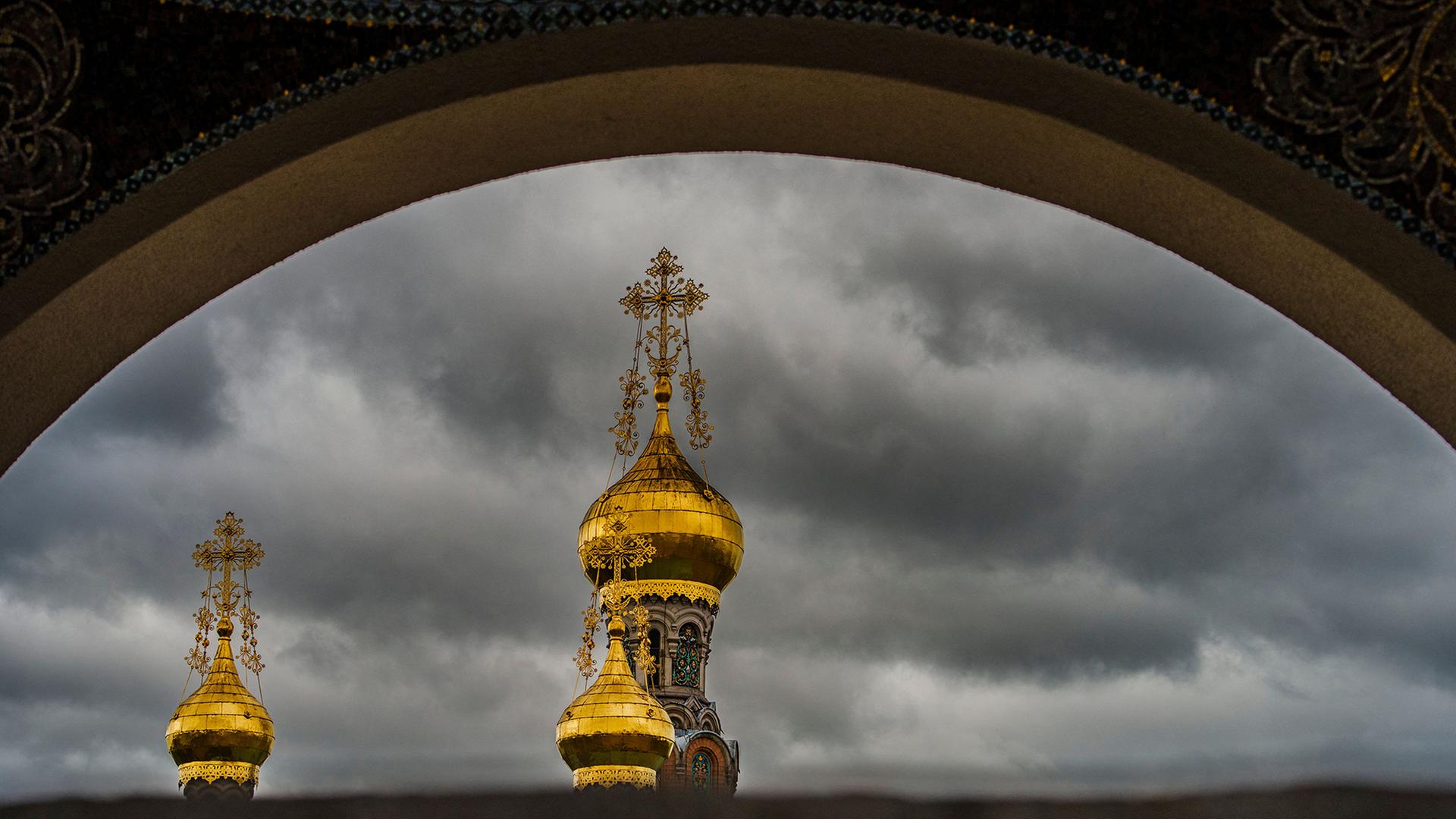 Dunkle Wolken ziehen an den vergoldeten Zwiebelkuppeln der russischen Kapelle von Darmstadt, Hessen, vorbei | Andreas Arnold/dpa