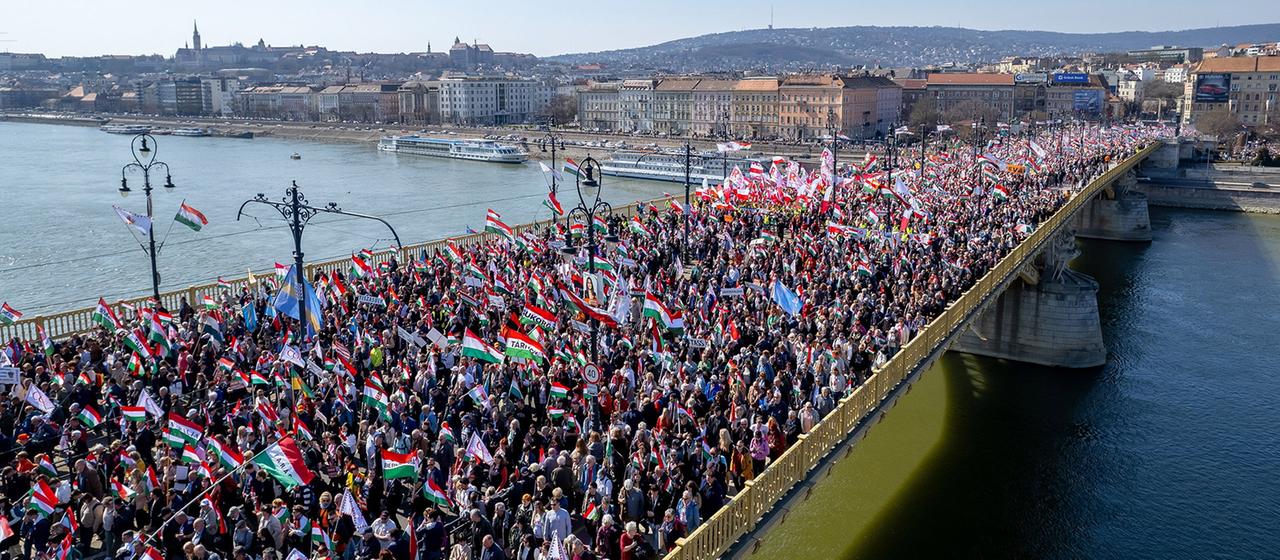 Menschenmassen mit Ungarn Flaggen laufen auf der Margaretenbrücke in Budapest.