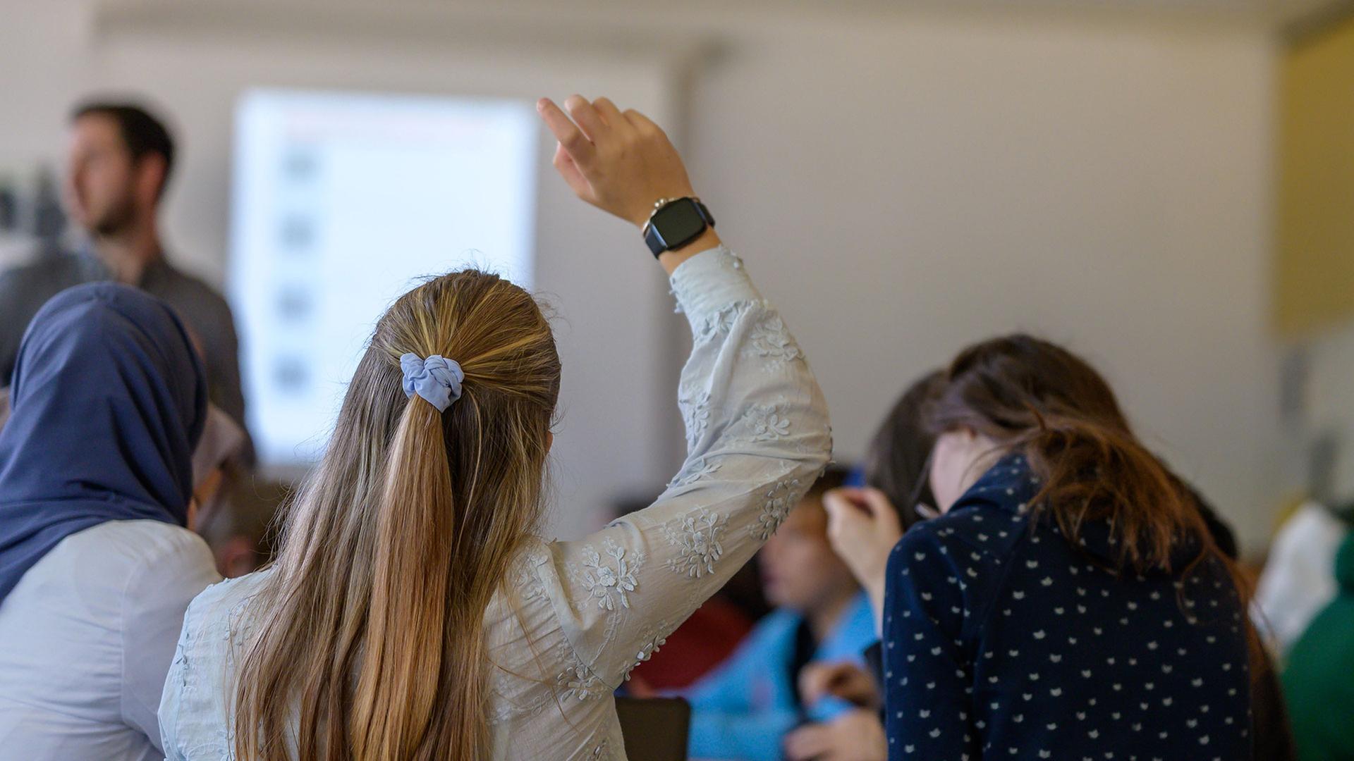 Eine Schülerin in der Oberstufe meldet sich im Unterricht | IMAGO / Funke Foto Services