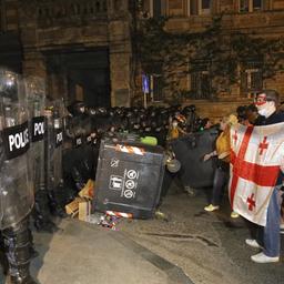 Polizisten blockieren in Tiflis eine Straße vor Demonstranten