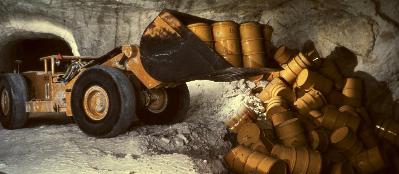 Ein Radlader kippt Atommüllfässer in die Schachtanlage Asse.