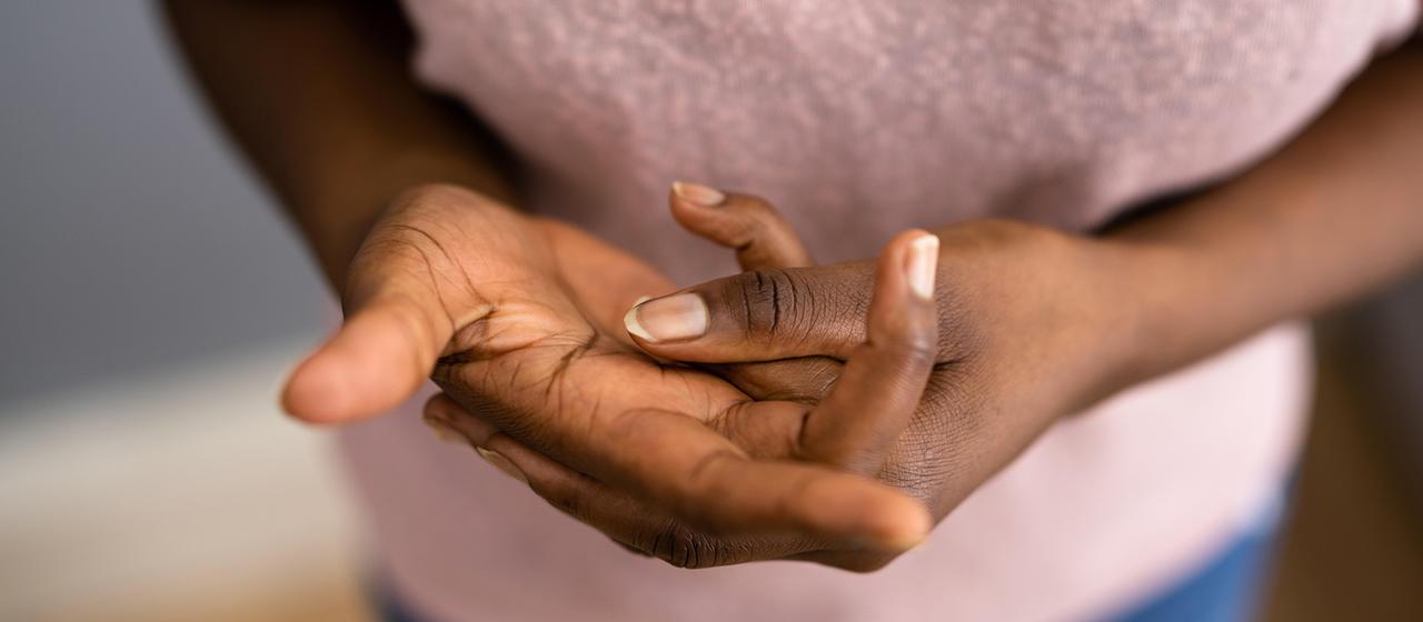 Eine Frau reibt sich die Hände.