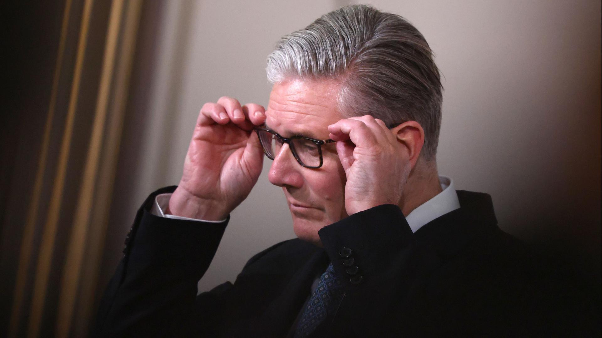Keir Starmer setzt sich eine Brille auf. | Tom Nicholson/Pool Getty Images/