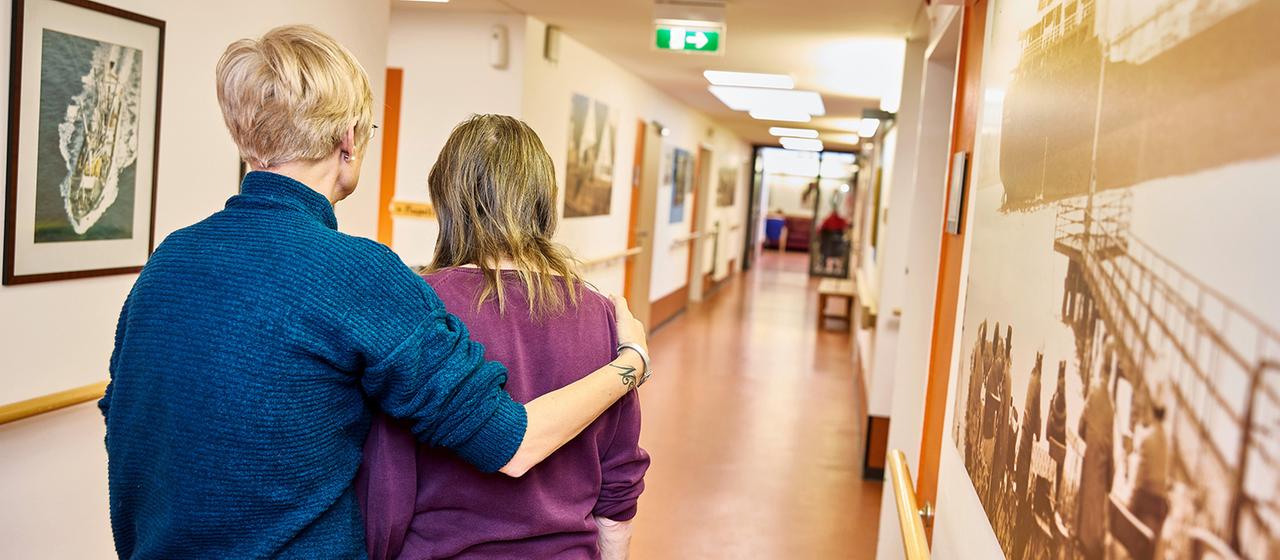 Pflegekraft mit einer Bewohnerin auf der Demenzstation in einem Pflegeheim