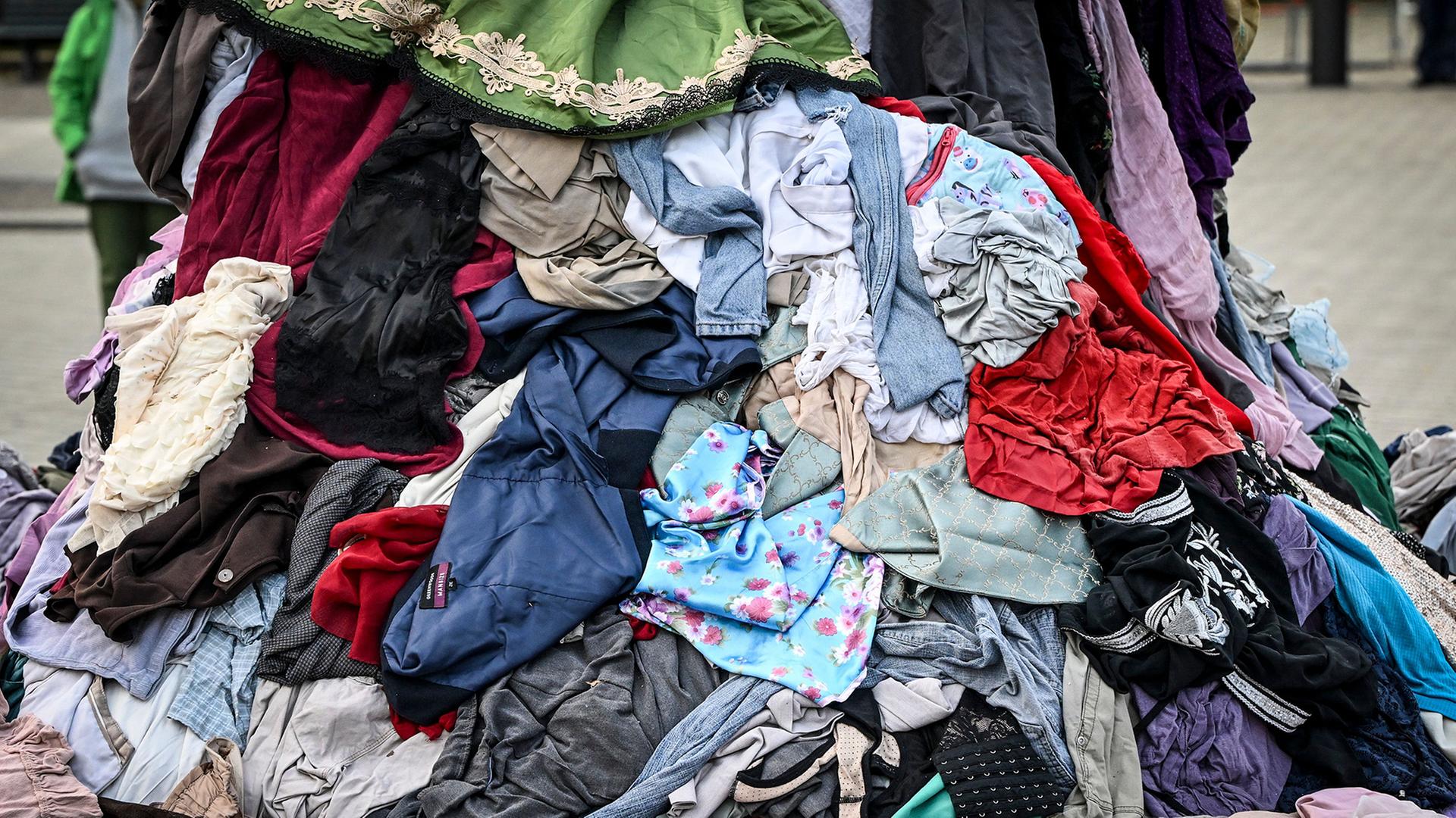 Kleidung liegt auf einem Haufen auf einer Straße. | Jens Kalaene/dpa