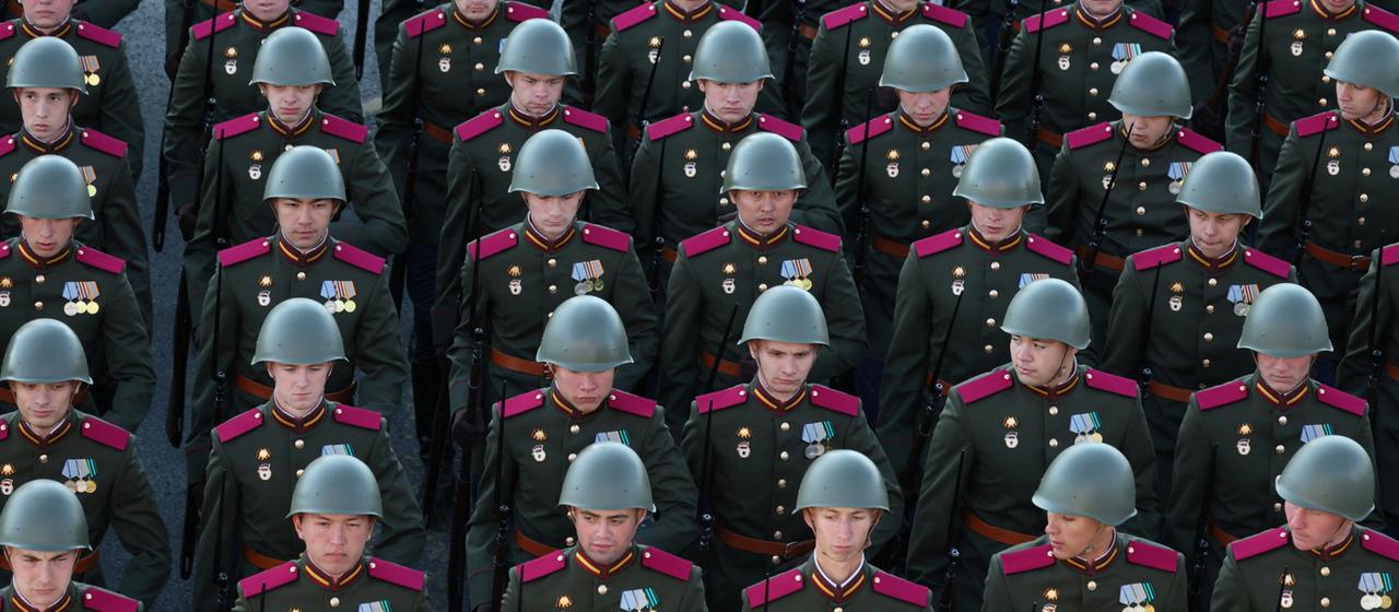 Russische Soldaten mit Helmen marschieren bei einer Militärparade