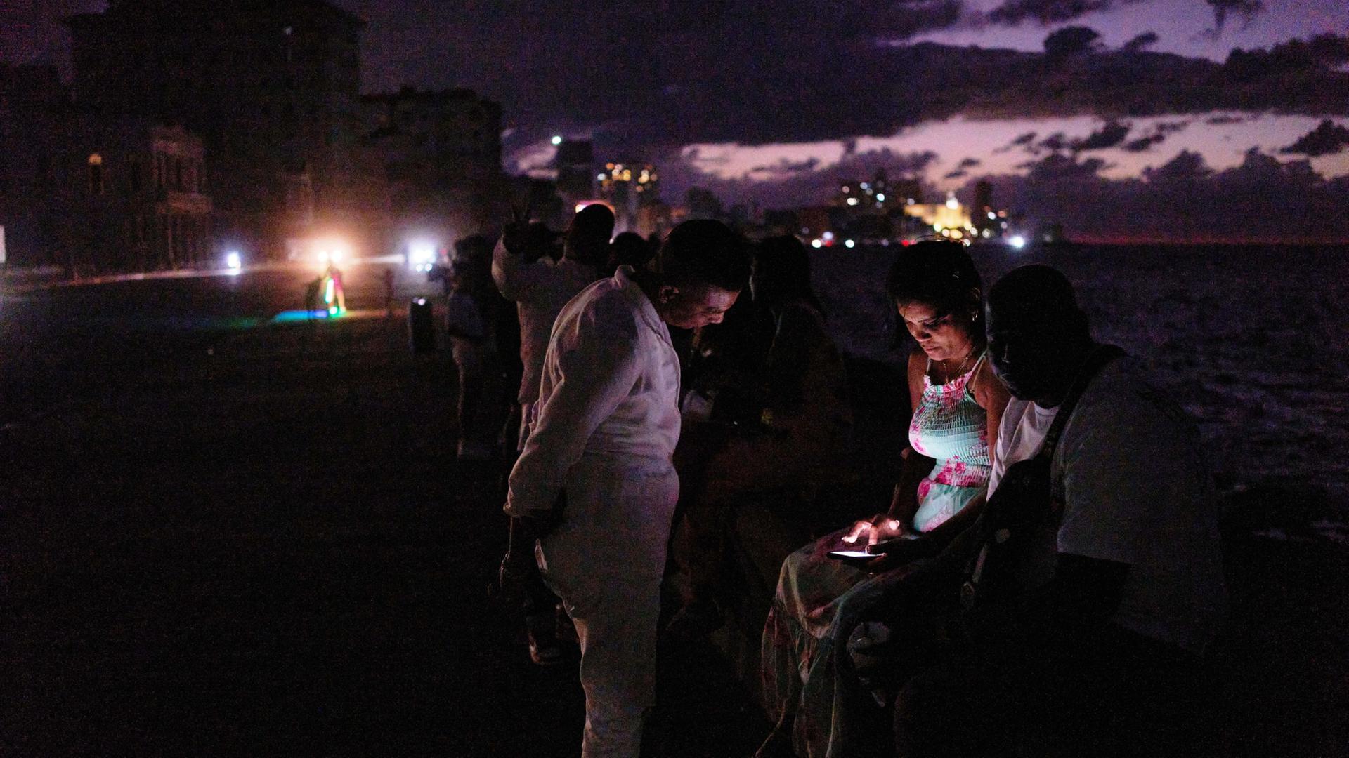 Menschen verbringen die Nacht im Dunkeln auf dem Malecon während eines Stromausfalls in Havanna. | Ramon Espinosa/AP/dpa