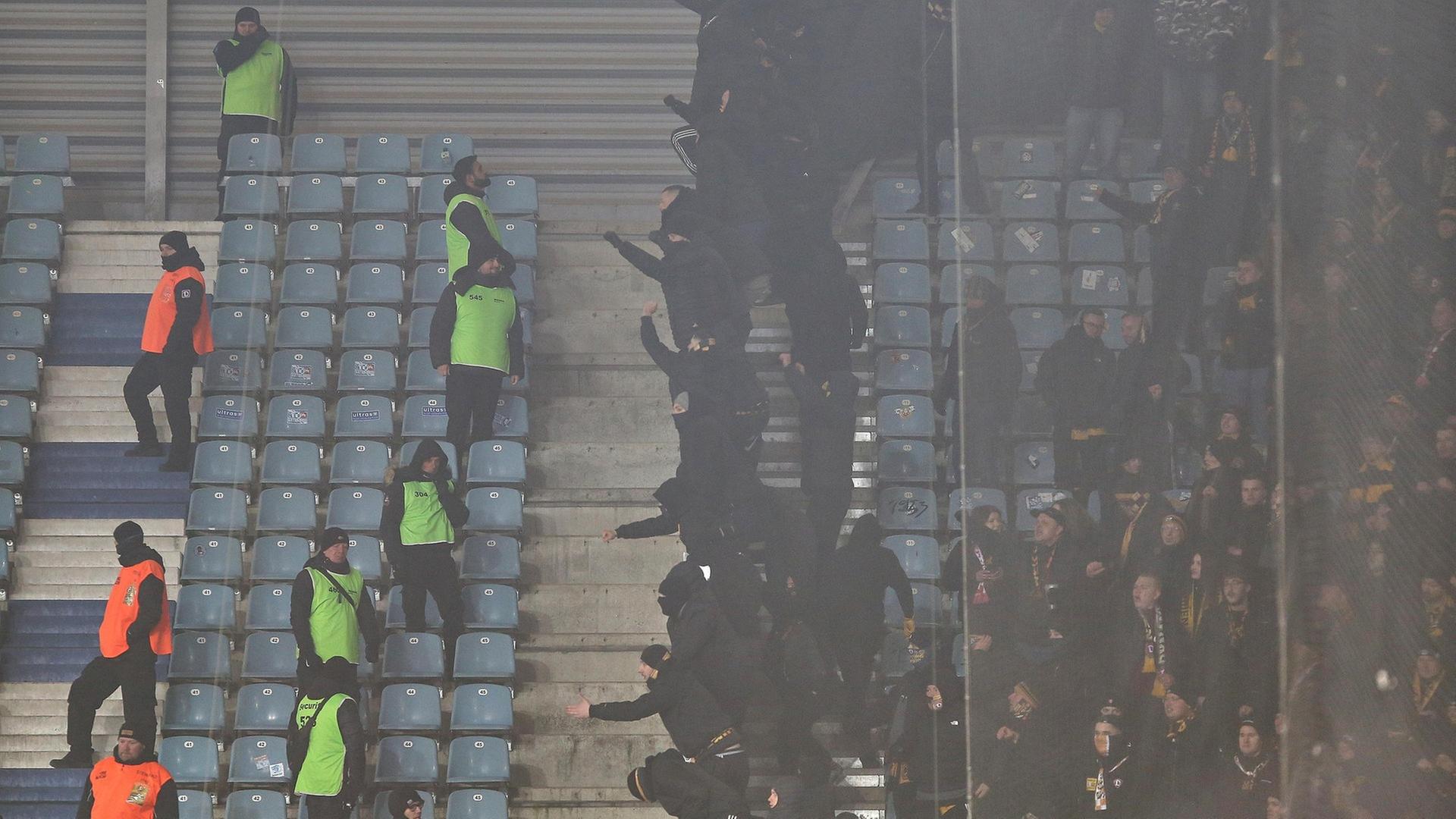 Fans gestikulieren aus ihrem Block in Richtung mehrerer Ordnnungskräfte. | picture alliance / dts-Agentur | -