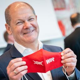 Bundesfinanzminister Olaf Scholz posiert im Bundestag mit einem Mund-Nasen-Schutz.