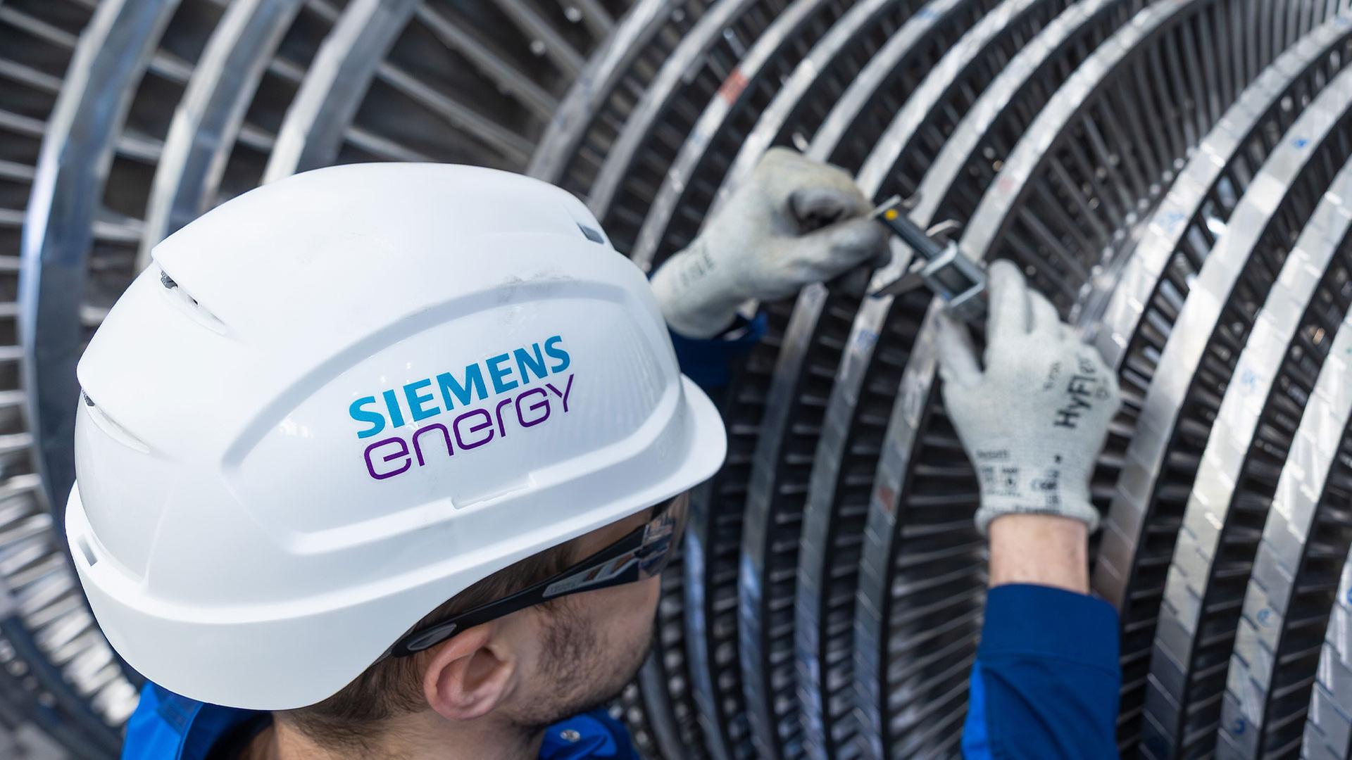 Ein Mitarbeiter von Siemens Energy arbeitet an einer Dampfturbine. | picture alliance/dpa