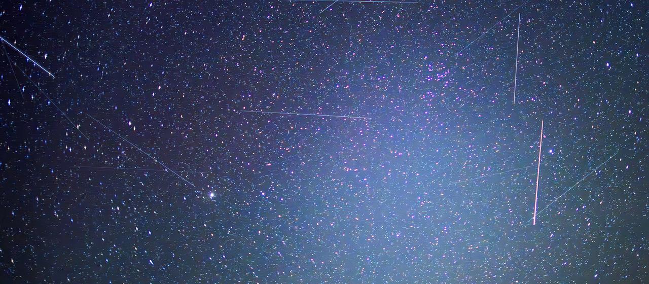 Satelliten sind als Leuchtspuren zwischen Sternen zu sehen (lange Belichtungszeit).