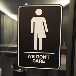 Geschlechtsneutrales Piktogramm am Eingang einer Hoteltoilette mit der Aufschrift: "We don't care" (deutsch: "Uns egal").