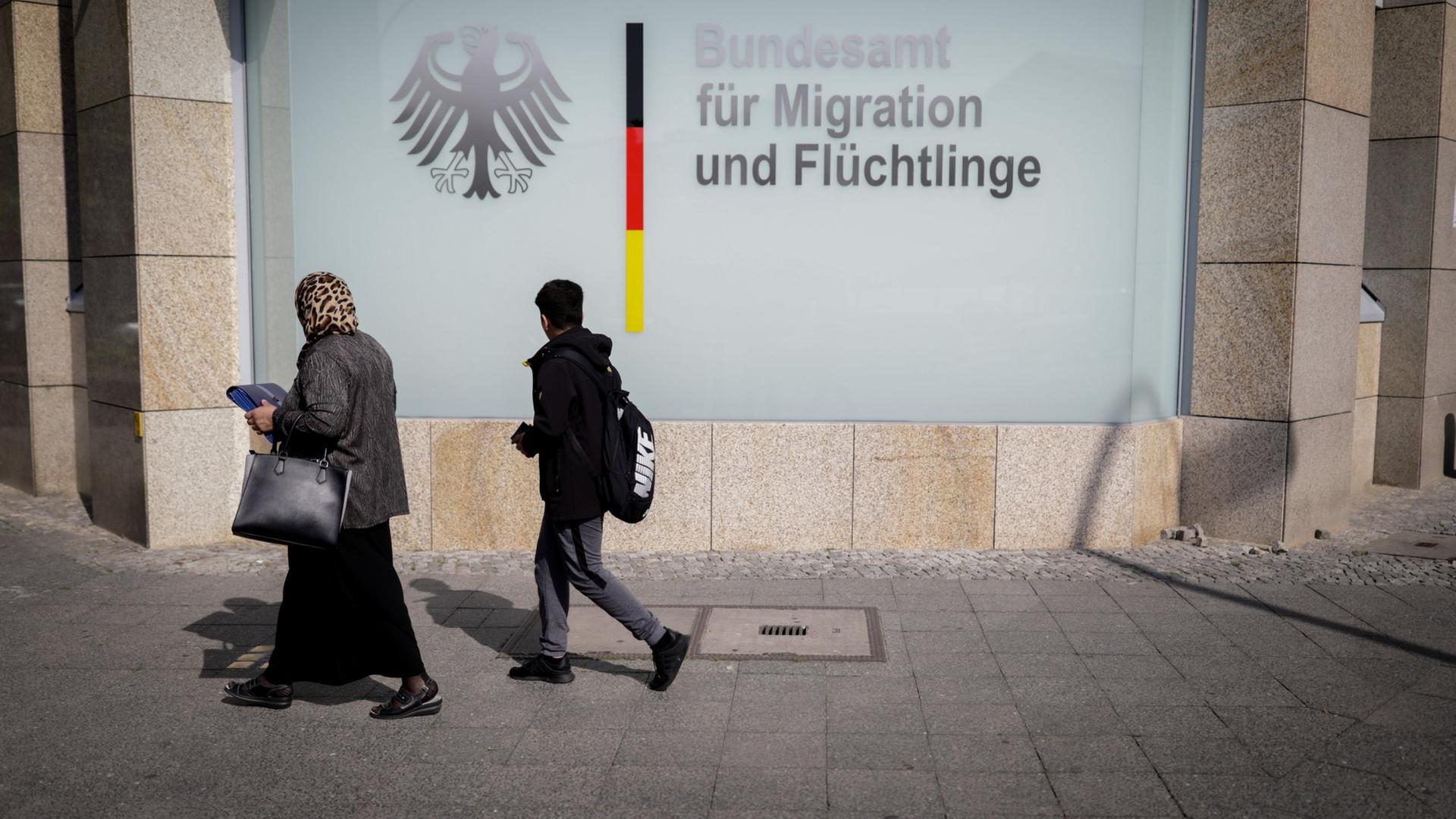 Passanten vor einem Gebäude des Bundesamts für Migration und Flüchtlinge in Berlin. | dpa