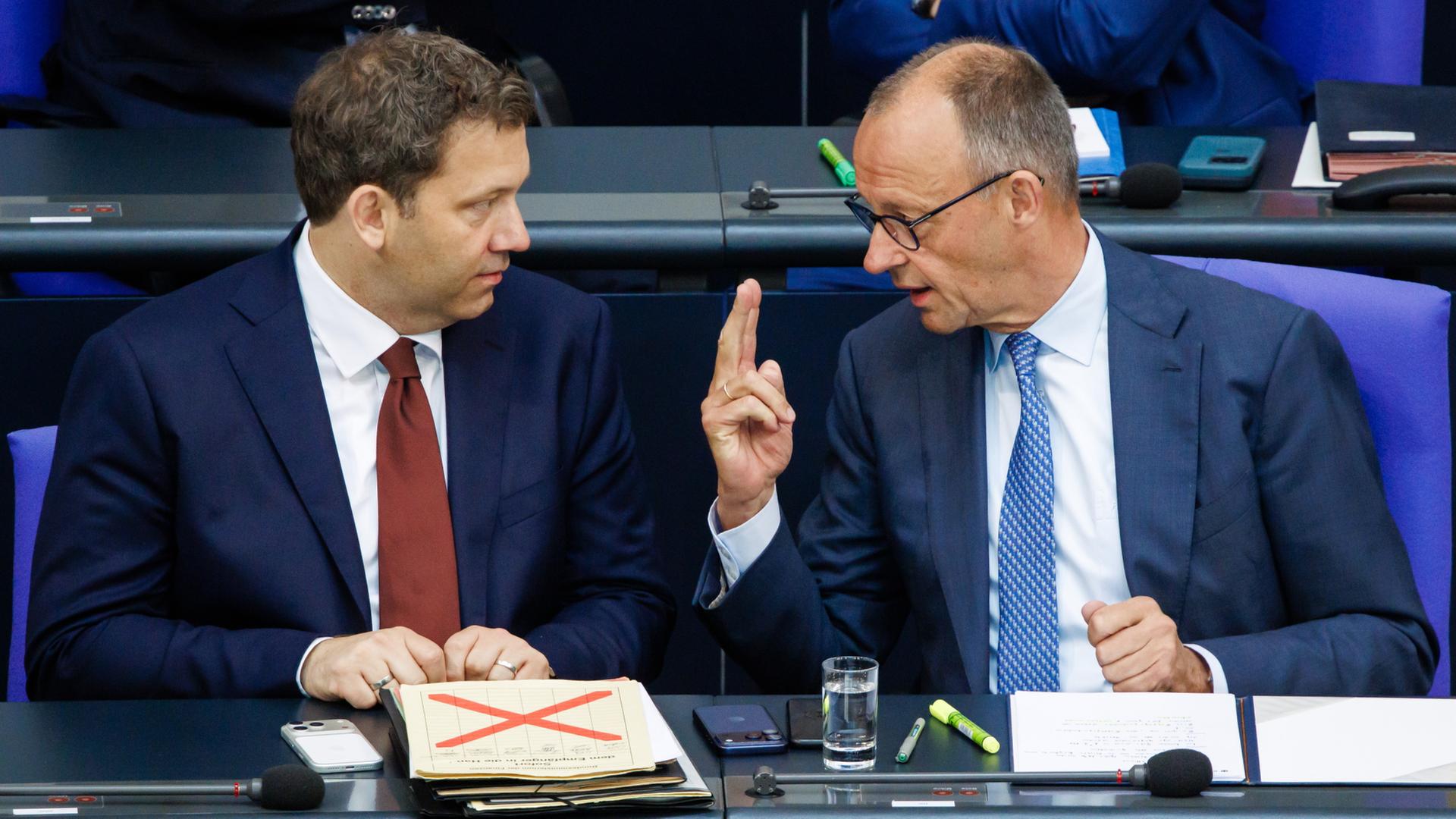 Lars Klingbeil und Friedrich Merz unterhalten sich im Bundestag. | EPA