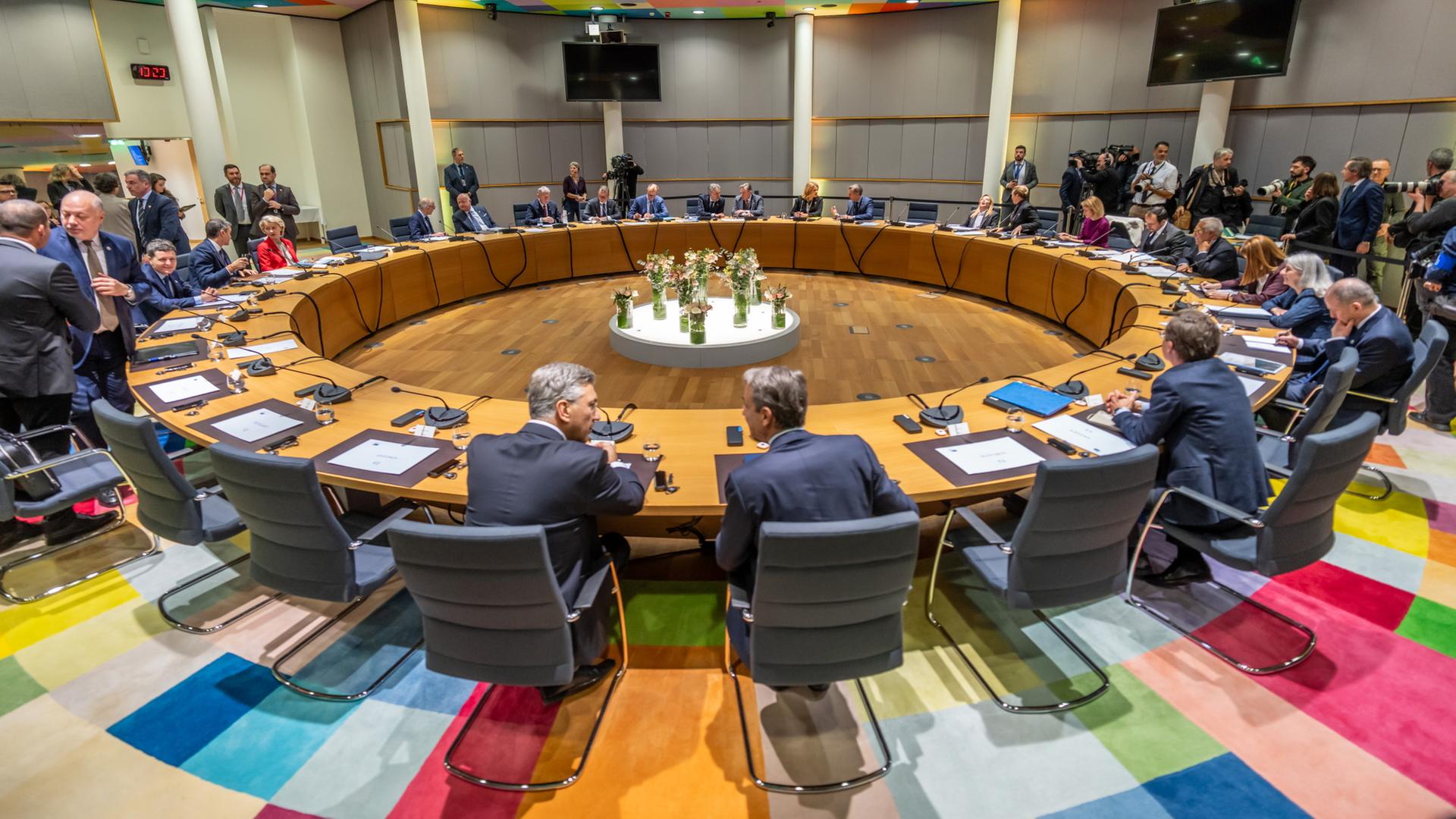 Staats- und Regierungschefs der EU sitzen und stehen an einem runden Tisch | dpa