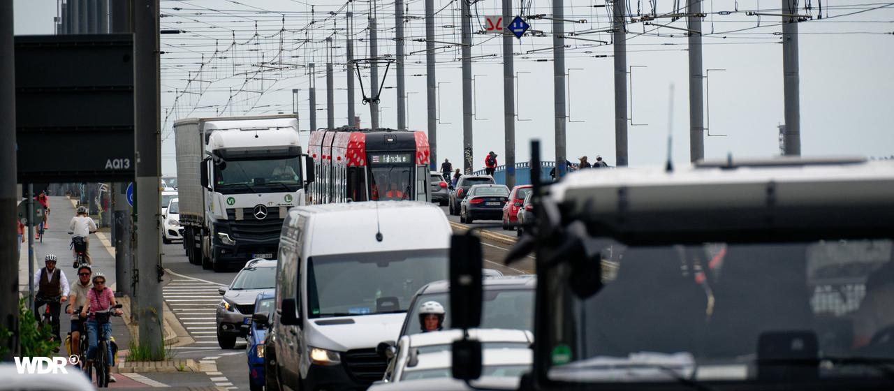Viele Autos, Lkw und eine Stadtbahn drängeln sich auf einer Brücke