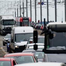 Viele Autos, Lkw und eine Stadtbahn drängeln sich auf einer Brücke