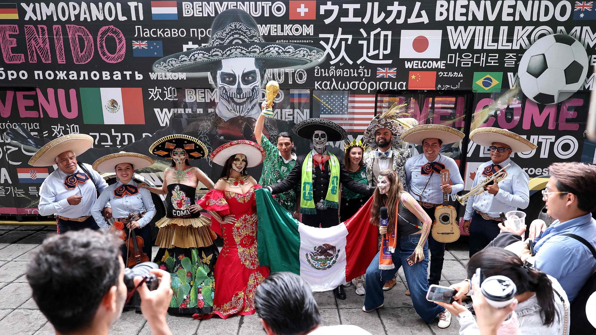 Kostümierte posieren mit Fußballfans in Mexiko | Getty Images via AFP