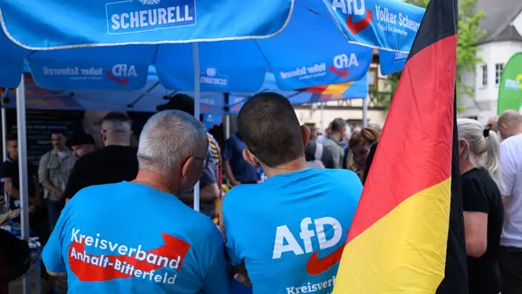 Besucher eines Infostands der AfD stehen auf dem Marktplatz in Bitterfeld.