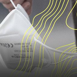 Eine Passantin trägt eine FFP2-Maske in der Hand.