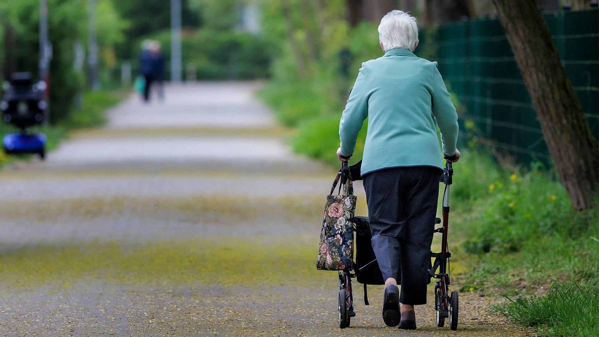 Seniorin mit Rollator in einem Park. | picture alliance / photothek.de