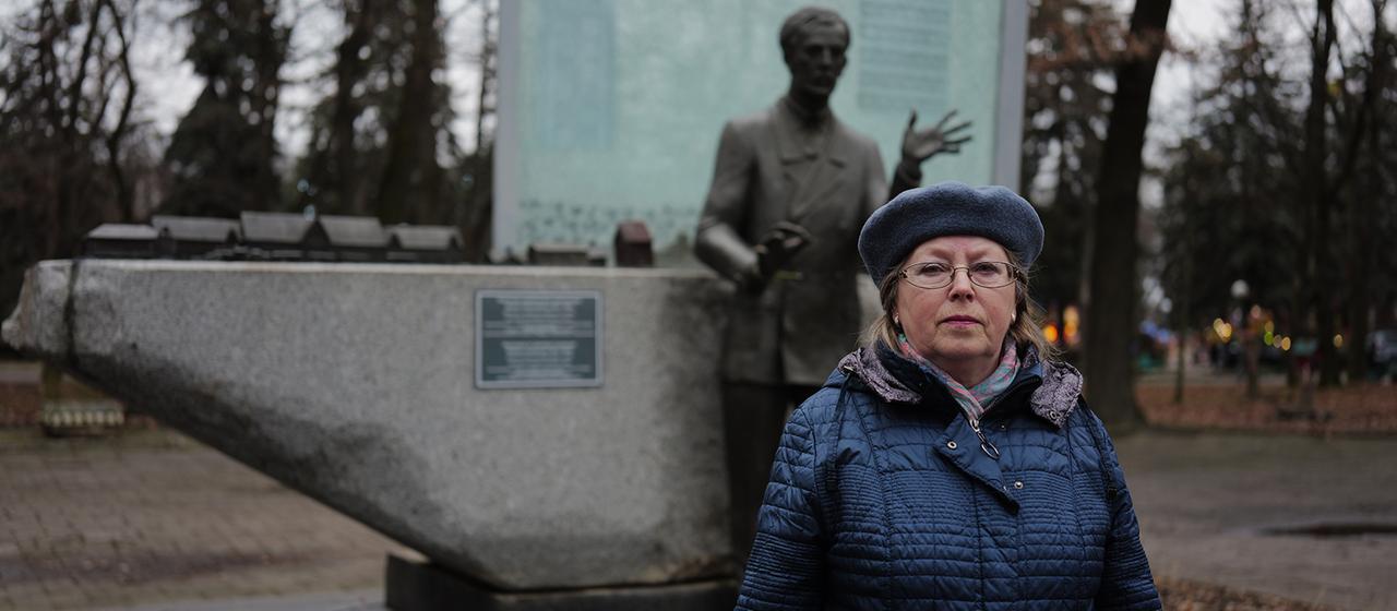 Eine Frau steht vor eine Leontowytsch-Denkmal.