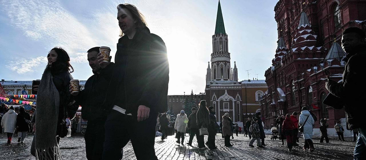 Menschen gehen in der Nähe des Staatlichen Historischen Museums im Zentrum von Moskau. 