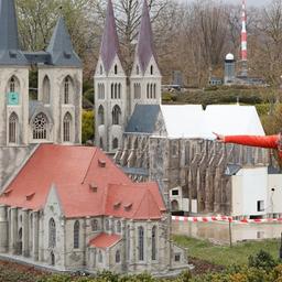 Ein Besucher weist seinen Sohn auf ein Modell der Martinikirche im Miniaturenpark Harz hin, im Hintergrund rechts eine Nachbildung des Halberstädter Doms. 