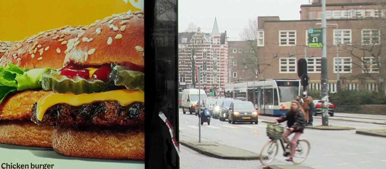 Ein Werbeplakat für Burger, im Hintergrund eine Straße im Amsterdam