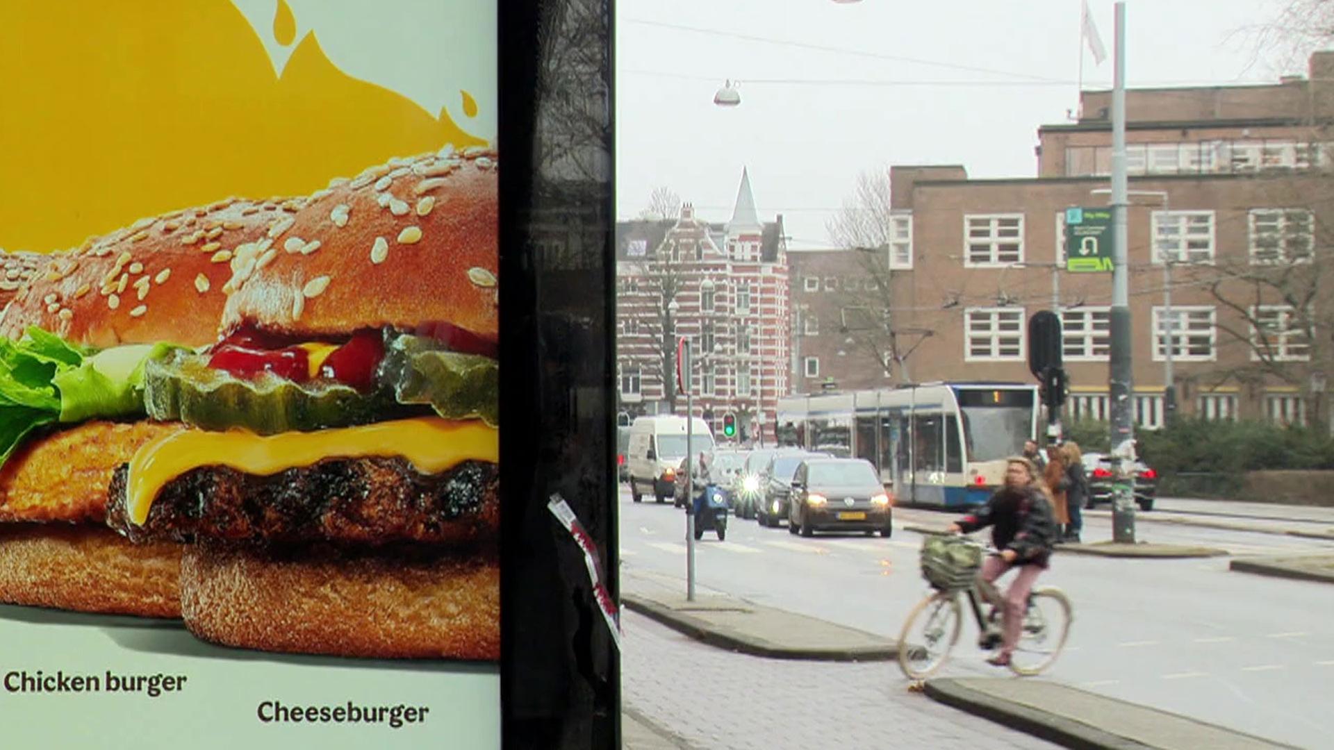 Ein Werbeplakat für Burger, im Hintergrund eine Straße im Amsterdam | ARD-aktuell