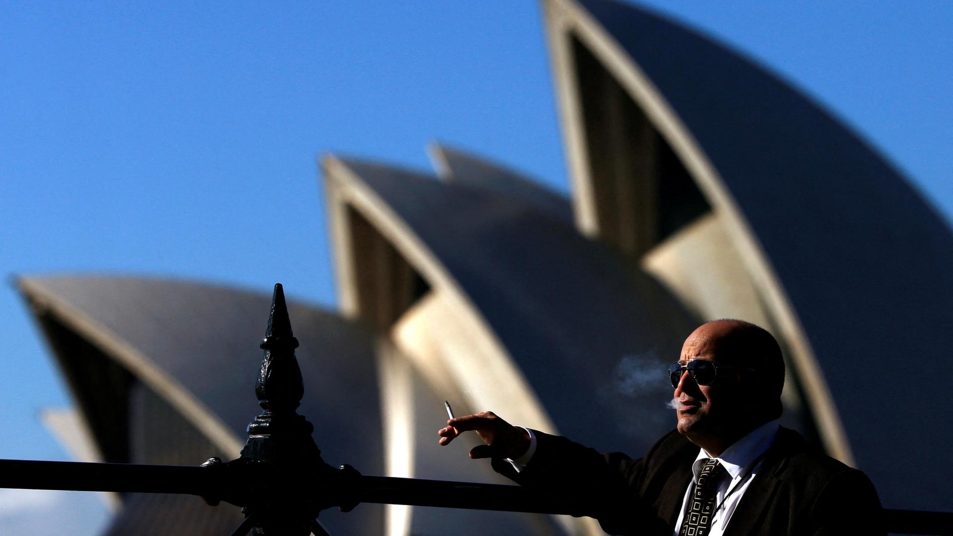 Ein Raucher steht vor der Oper in Sydney. | REUTERS