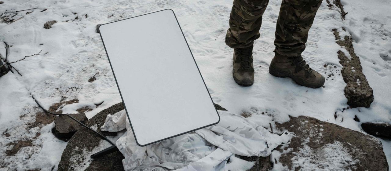 Ein ukrainischer Soldat steht neben einer Starlink-Antenne (Archivbild)