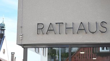 Ein Hinweisschild mit der Aufschrift "Rathaus" hängt an dem Rathausgebäude in Rottenburg am Neckar.