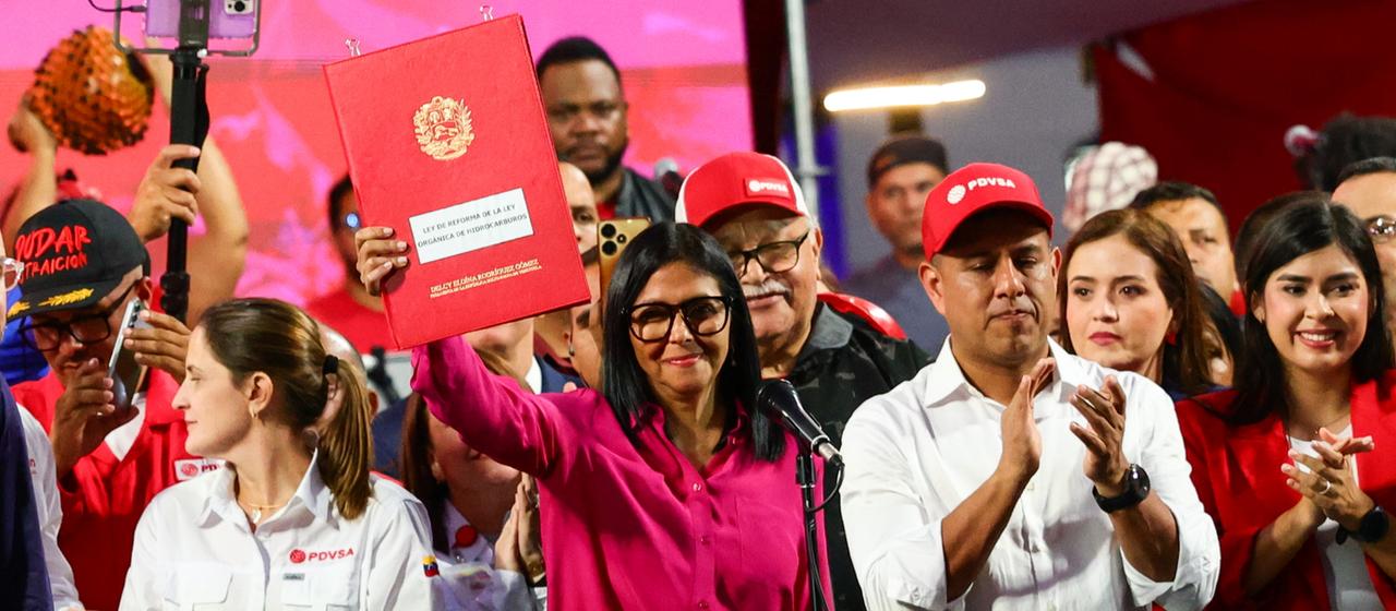 Die amtierende venezolanische Präsidentin Delcy Rodriguez nimmt an einer Kundgebung teil, bei der sie eine Kopie eines neuen Gesetzes hochhält.