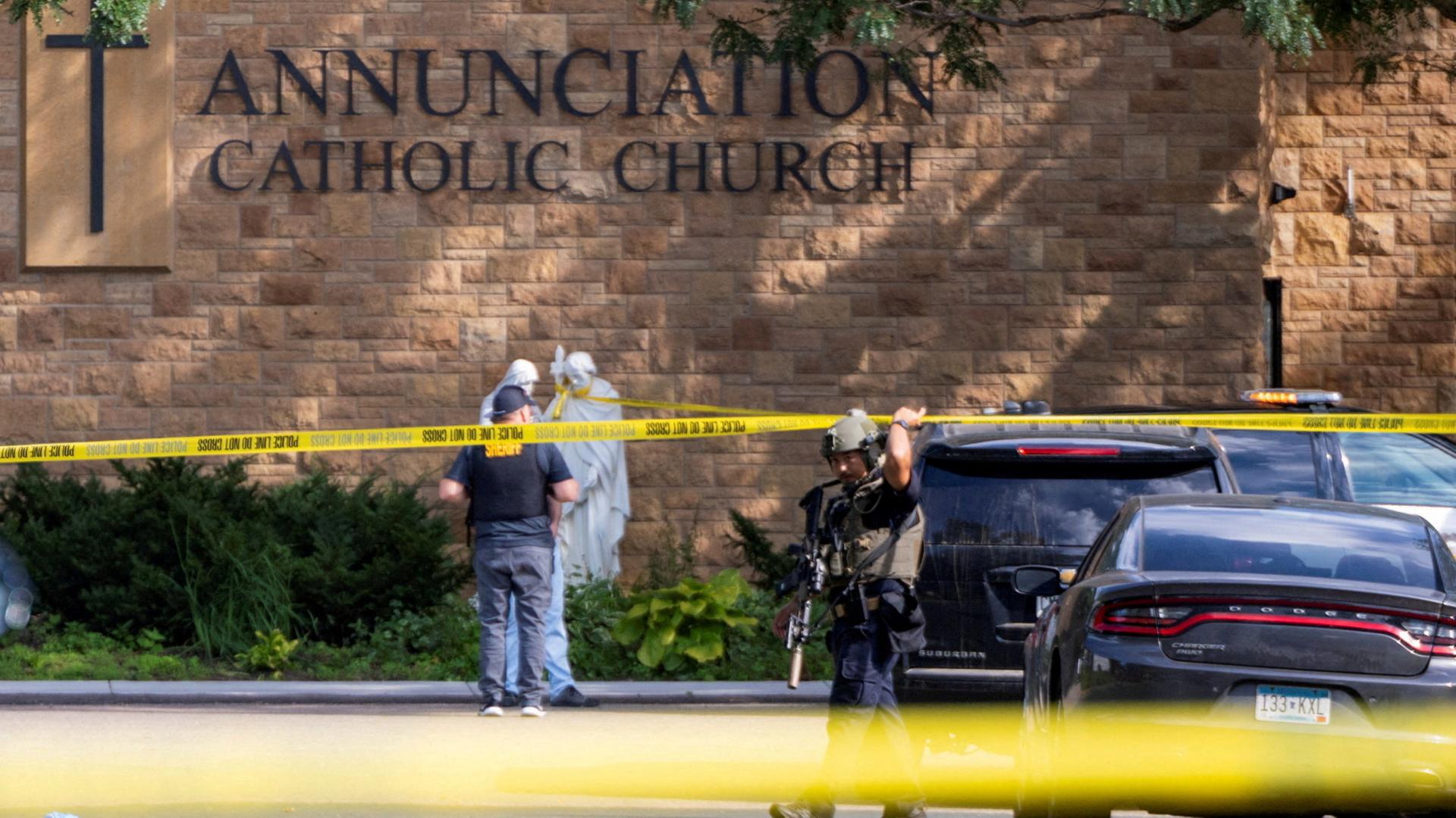 Sicherheitskräfte stehen hinter einem Absperrband vor einer Kirche in Minnesota, in der ein Schütze auf Schulkinder geschossen hat. | REUTERS