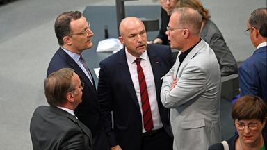 Jens Spahn, Alexander Hoffmann und Matthias Miersch sprechen im Bundestag miteinander.