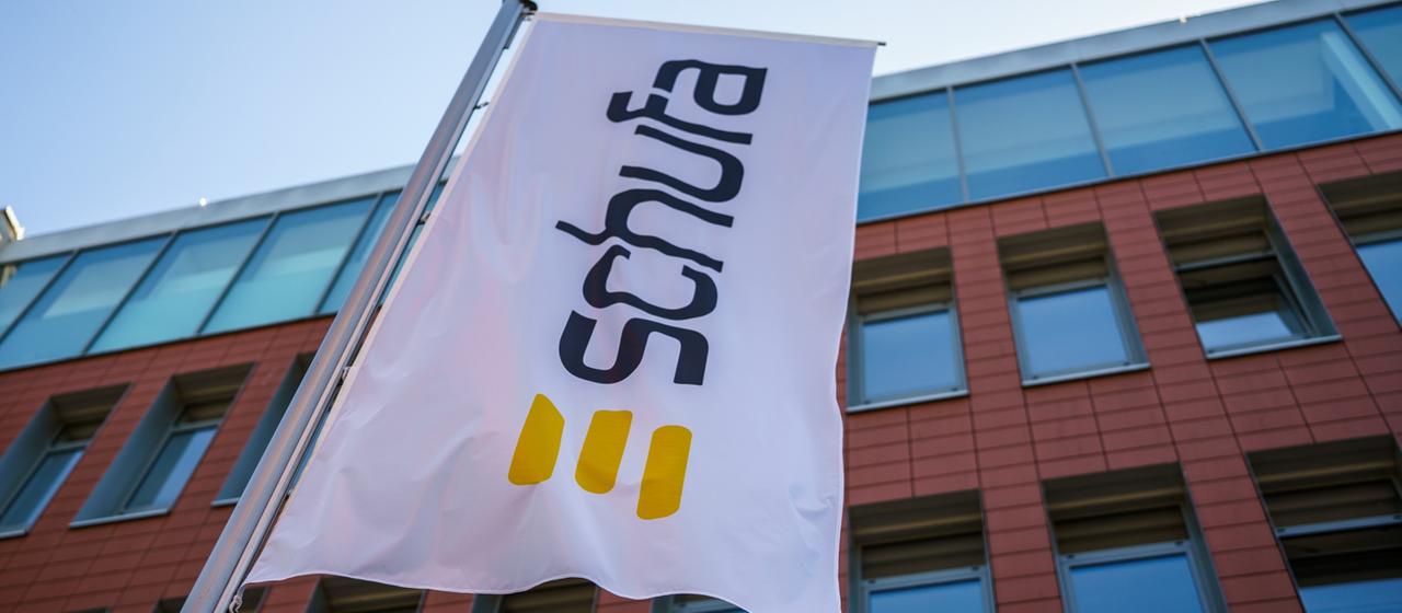 Eine Flagge mit dem Firmenlogo der Schufa flattert vor dem Geschäftssitz in der Landeshauptstadt.