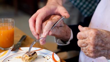 Ein junger Mann, der ein Freiwilliges Soziales Jahr (FSJ) absolviert, hilft einer Bewohnerin einer Wohngemeinschaft für Demenzkranke (Archivbild, 2010).