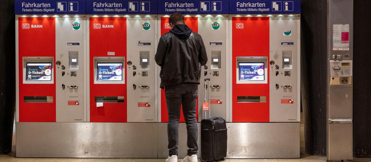 Ein Mann steht im Hauptbahnhof in Köln vor Fahrkartenautomaten.