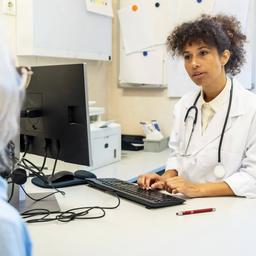 Eine Ärztin sitzt einer Patientin gegenüber.